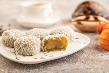 Japanese rice sweet buns mochi filled with pandan jam on brown concrete, side view, selective focus.