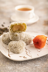 Japanese rice sweet buns mochi filled with pandan jam on brown concrete, side view, selective focus.