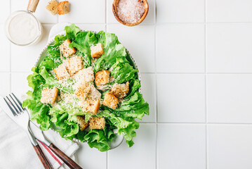 Traditional caesar salad with lettuce, wheat croutons, parmesan and sauce.