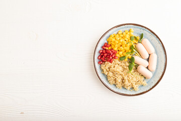 Mixed quinoa porridge, sweet corn and small sausages on white wooden, top view, copy space.