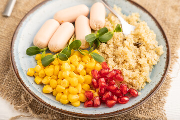 Mixed quinoa porridge, sweet corn and small sausages on white wooden, side view, selective focus.