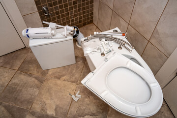 Installing a new toilet bowl in the restroom and its accessories, plumbing repair service,...