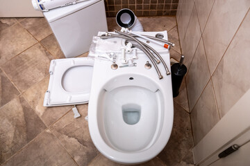 Installing a new toilet bowl in the restroom and its accessories, plumbing repair service,...