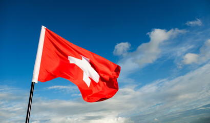 Swiss flag waving against sky