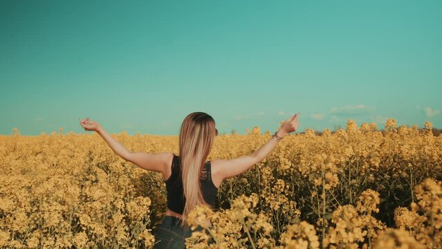 Beautiful sexy young woman on yellow flower meadow in sunset