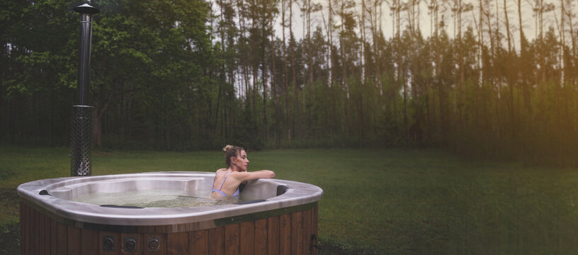 Young woman relax in hot tub SPA at the nature. Copy space image.