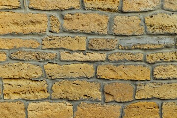 Background, texture wall stacked of yellow natural sandstone stone