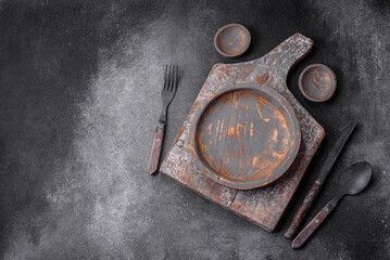 Fototapeta na wymiar Empty wooden plate, knife, fork and cutting board