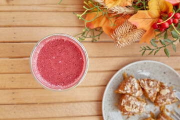 Aesthetic healthy autumn lunch - pink strawberry smoothie and french tart on the wooden table