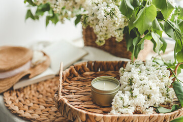 Candle on a tray and white lilac, spring interior