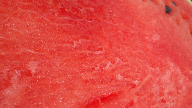 Macro video of watermelon using a probe lens captures its vibrant colors, juicy texture, and intricate seed patterns. The lens reveals mesmerizing details. Shot with laowa 24mm probe lens. Dolly shot
