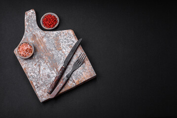 Knife, fork and cutting board, salt, pepper and other ingredients