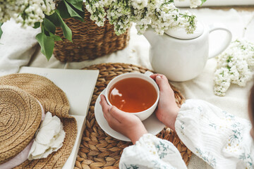 A cup of tea in hands on a background of lilac, top view, aesthetic photo
