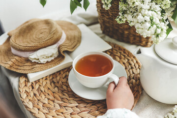 A cup of tea in hands on a background of lilac, top view, aesthetic photo