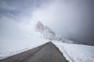 Mountain in fog with snow and road