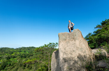 Man with backpack on top of rock