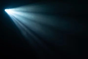 Rolgordijnen blue spotlight light beam on black background © nazarioking