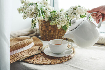 Tea is pouring into a cup from a teapot, beautiful aesthetic photo
