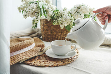 Tea is pouring into a cup from a teapot, beautiful aesthetic photo