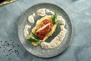 Baked chicken breast with mashed potatoes and mushroom sauce in a plate