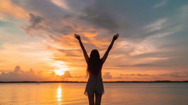 Happy woman silhouette in the sunset