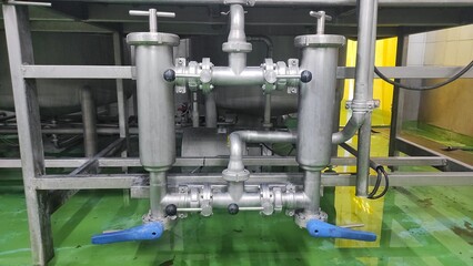 Fototapeta na wymiar the pipe for filter and valve from tank to the filling machine in production room of factory