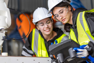 A team of female engineers meeting to inspect computer-controlled steel welding robots. Plan for rehearsals and installation for use.