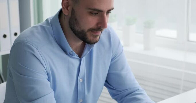 Caucasian businessman sitting in his office, engrossed in deep thought as he tries to devise ways to enhance his company's profitability. He is seen staring intently at his computer screen.