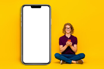 Full length portrait of cheerful person sit floor use gadget social network isolated on yellow color background