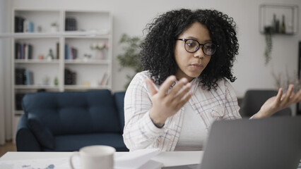 Anxious African American woman having problems with work tasks, correcting errors on her laptop
