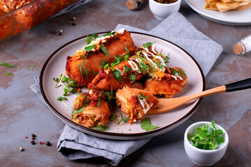 Enchiladas with crepes, chicken meat, tomato sauce and cheese served with sour cream and herbs. Fusion cuisine meal