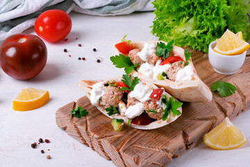 Pita pocket stuffed with meatballs and vegetables topped with sour cream and cilantro. Arabian, Turkish and Greek cuisines meal