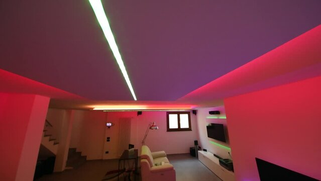 Led strips lighting in a modern living room with sofa, desk and TV screen