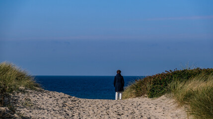 Eine Frau schaut aufs Meer auf der Insel Sylt