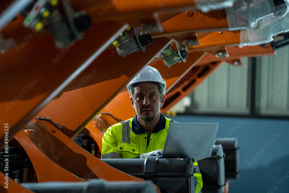 Poster robot engineer working with robotic arms working on assembly line of appliance manufacturing factory