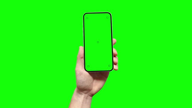 A man is holding a smartphone with a blank green screen featuring tracking marks, and he is touching with his finger the screen in the app. This serves as a template for your application