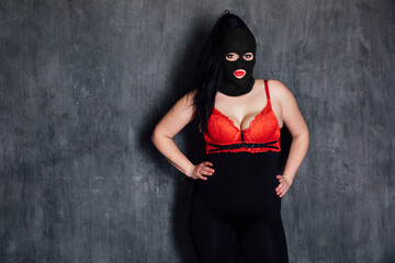 masked woman in a dark basement room