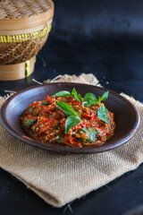 sambel terasi ulek or chili paste in black background
