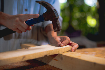 Carpenter with hummer hitting nails