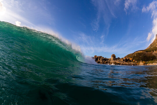 crashing wave breaking in the ocean with a blue sky background and copy space