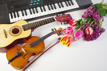 Fototapeta premium Guitar, violin, synthesizer and a bouquet of tulips and lilacs.