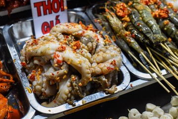 Many snacks and seafood in vietnamese night market with signs with vietnamese text 