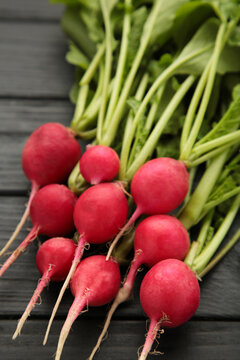 Fresh radishes on grey wooden background. Vertical photo
