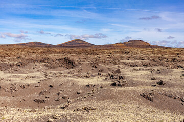 Volcanic landscape. The crater of an extinct volcano in a valley on the Canary Island. Tourism.