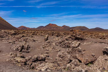 Volcanic landscape. The crater of an extinct volcano in a valley on the Canary Island. Tourism.