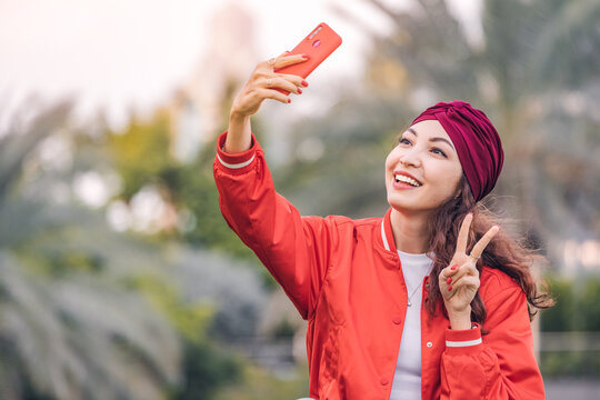 Happy malaysian girl influencer taking selfie photos for her social media and followers
