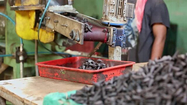 Manufactured or moulded incense cones drop from the conveyor belt at the factory