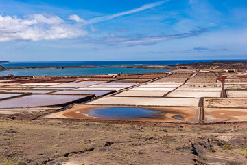 Construction of small stone on sand. Stone barriers on the seashore. Canary Islands. - obrazy, fototapety, plakaty