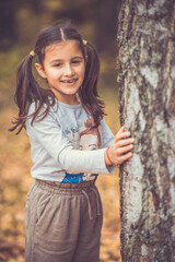 Child in the forest smiling and playing