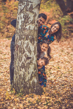Happy smiling beautiful family playing and laugh in the forest
